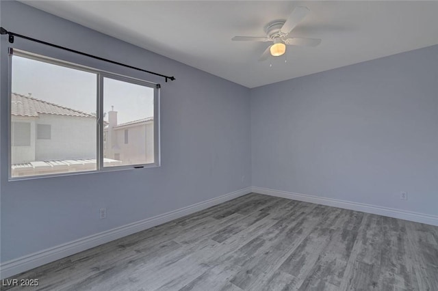 spare room with ceiling fan and light wood-type flooring