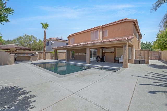 exterior space with a patio area and a pool with hot tub