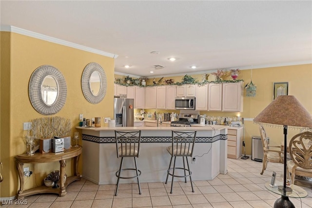 kitchen featuring white cabinetry, kitchen peninsula, appliances with stainless steel finishes, a kitchen breakfast bar, and crown molding