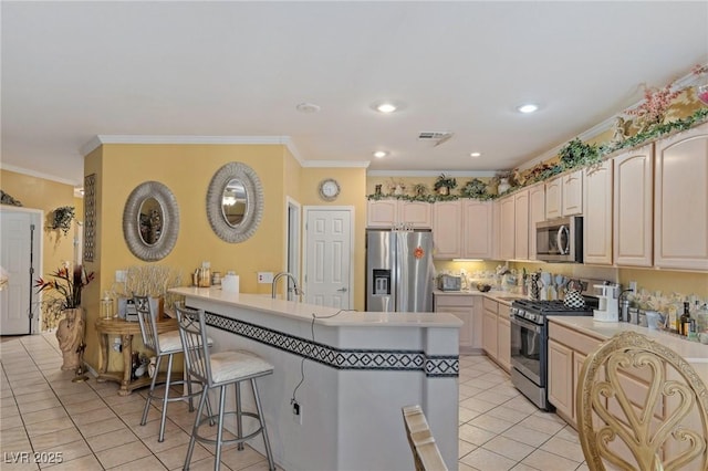 kitchen with kitchen peninsula, a kitchen breakfast bar, stainless steel appliances, ornamental molding, and light tile patterned floors