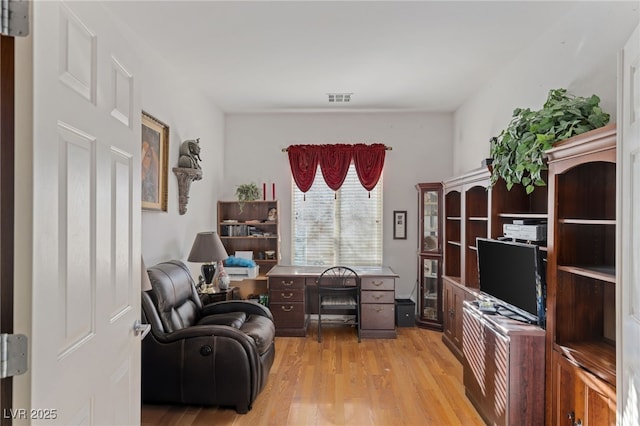 home office with light hardwood / wood-style flooring