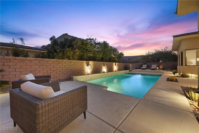 pool at dusk with a patio area