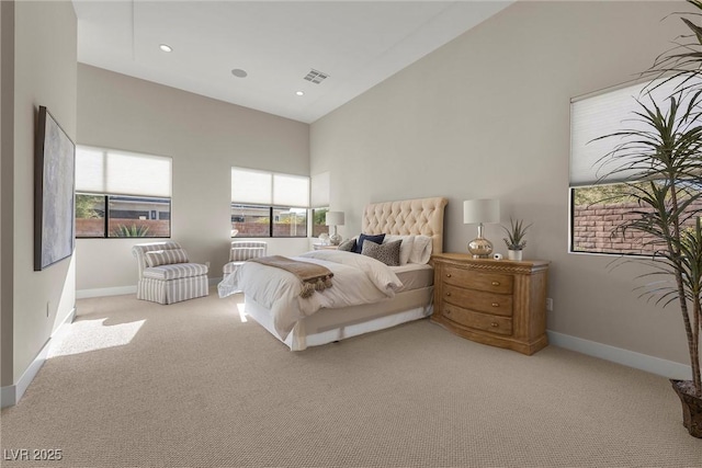 carpeted bedroom with high vaulted ceiling