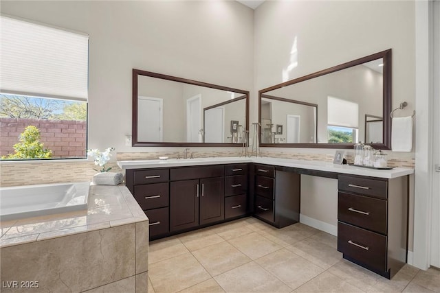 bathroom featuring tile patterned floors, tiled tub, and vanity