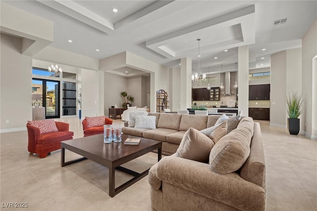 living room with a notable chandelier and a tray ceiling