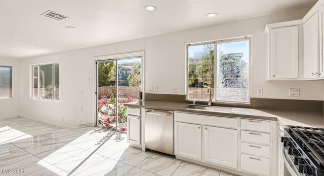 kitchen featuring white cabinets, appliances with stainless steel finishes, and sink