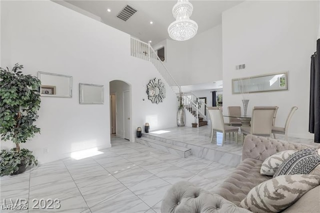 living room with a towering ceiling and a chandelier