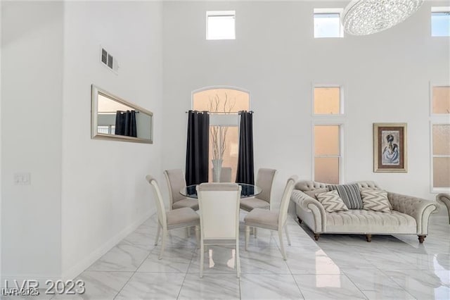 dining room with a towering ceiling and an inviting chandelier