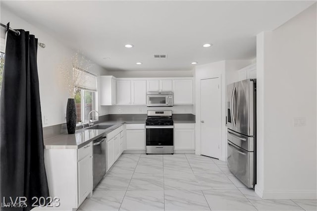 kitchen featuring white cabinets, appliances with stainless steel finishes, and sink