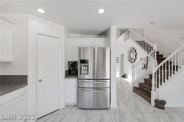 kitchen featuring stainless steel fridge with ice dispenser and white cabinetry