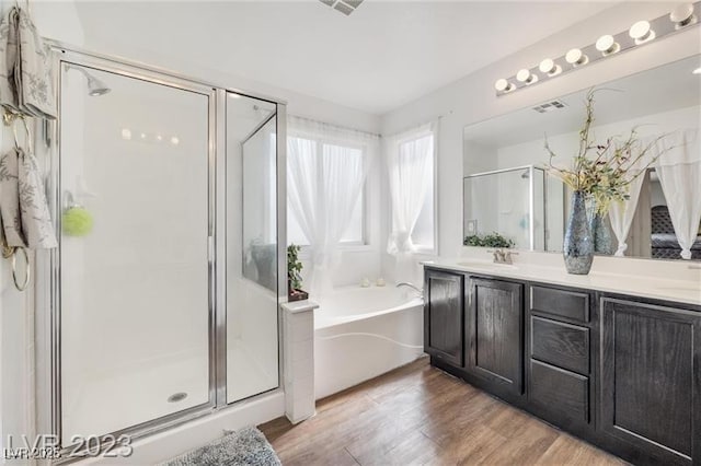 bathroom featuring hardwood / wood-style floors, vanity, and independent shower and bath