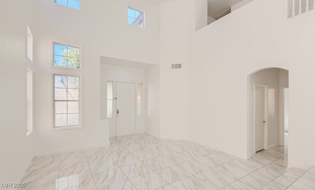 foyer entrance featuring plenty of natural light and a towering ceiling