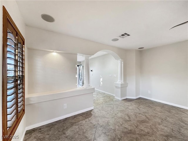 unfurnished room featuring ornate columns