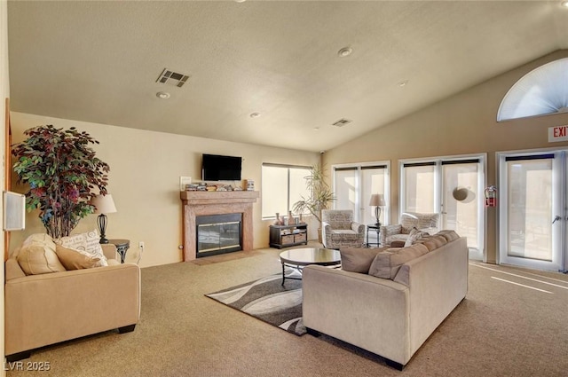 living room featuring lofted ceiling, a premium fireplace, and carpet floors