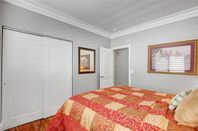 bedroom with crown molding, wood-type flooring, and a closet