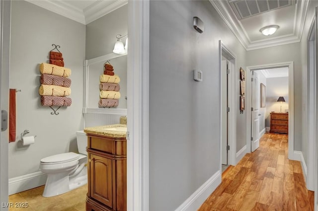 bathroom with ornamental molding, toilet, hardwood / wood-style floors, and vanity