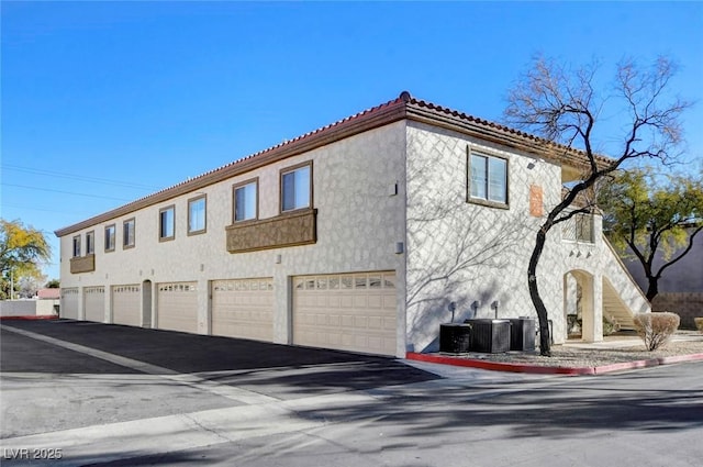 view of side of home featuring a garage and central AC unit