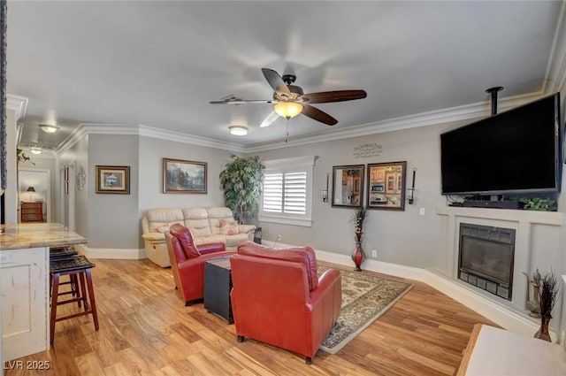 living room featuring crown molding, light hardwood / wood-style floors, and ceiling fan