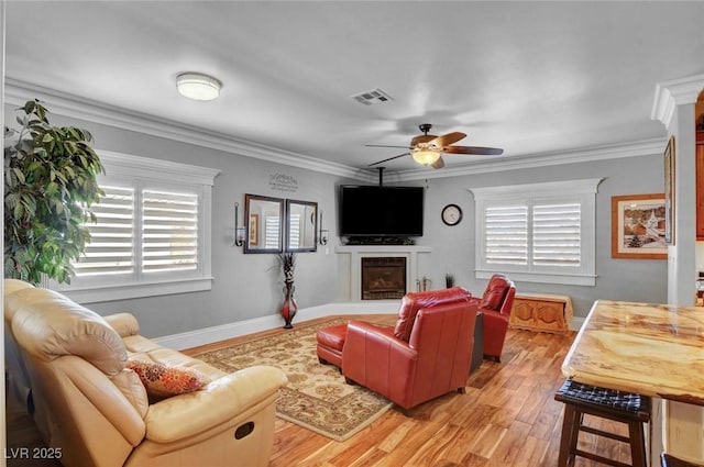 living room featuring crown molding, ceiling fan, and light wood-type flooring