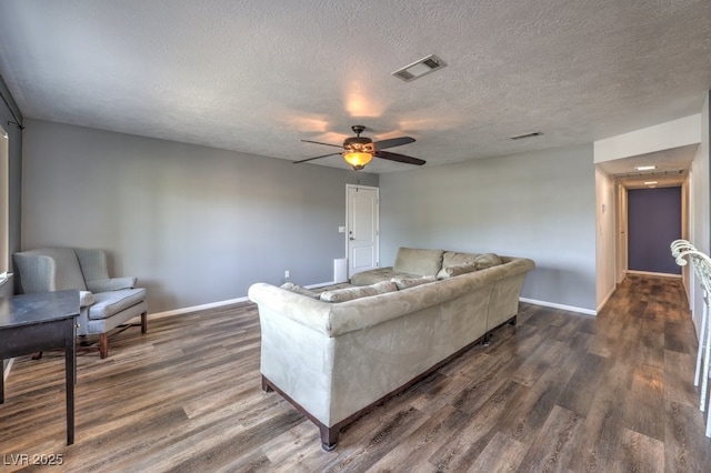 living room with dark hardwood / wood-style floors, ceiling fan, and a textured ceiling