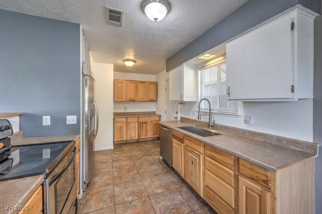 kitchen featuring appliances with stainless steel finishes, light brown cabinetry, a textured ceiling, sink, and white cabinets