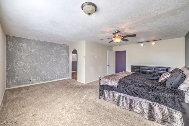 carpeted bedroom with ceiling fan and a textured ceiling