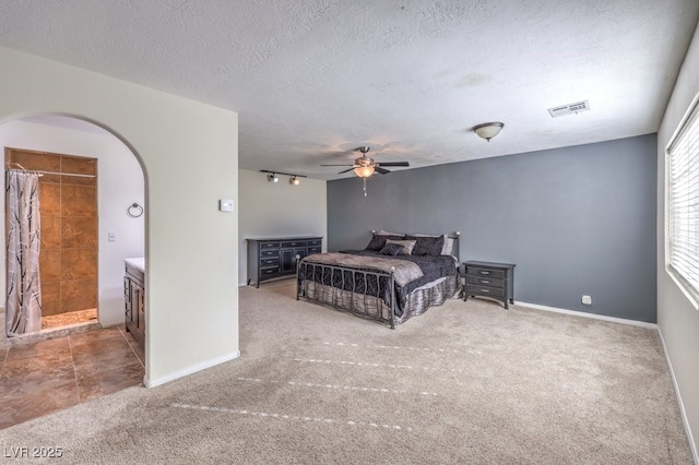 carpeted bedroom with ceiling fan and a textured ceiling