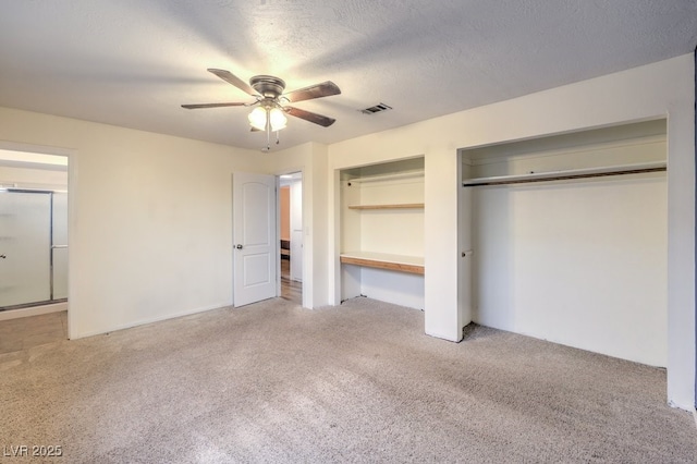 unfurnished bedroom with carpet flooring, ceiling fan, a textured ceiling, and a closet