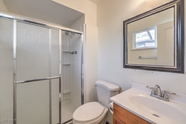 bathroom with walk in shower, vanity, and toilet