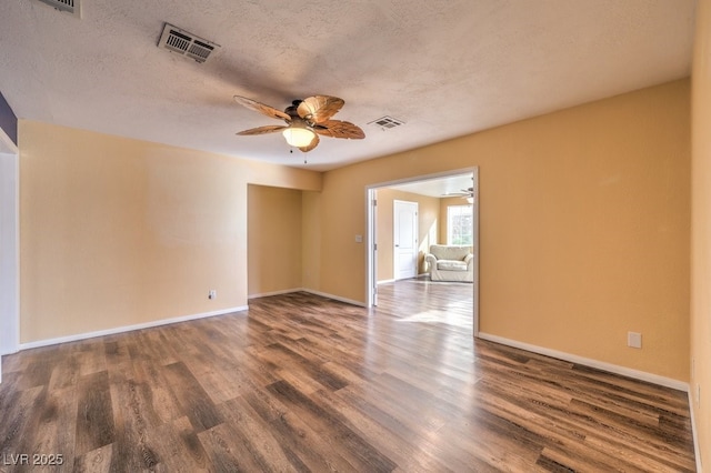 empty room with ceiling fan, dark hardwood / wood-style flooring, and a textured ceiling