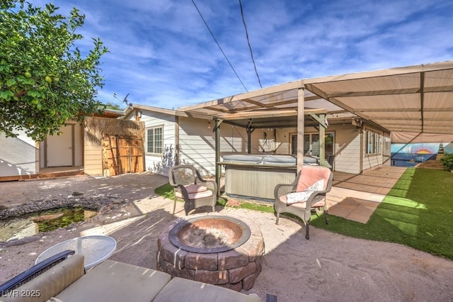 view of patio / terrace featuring a fire pit and a hot tub