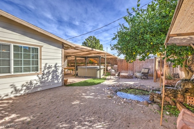 view of yard featuring a fire pit, a patio, and a hot tub