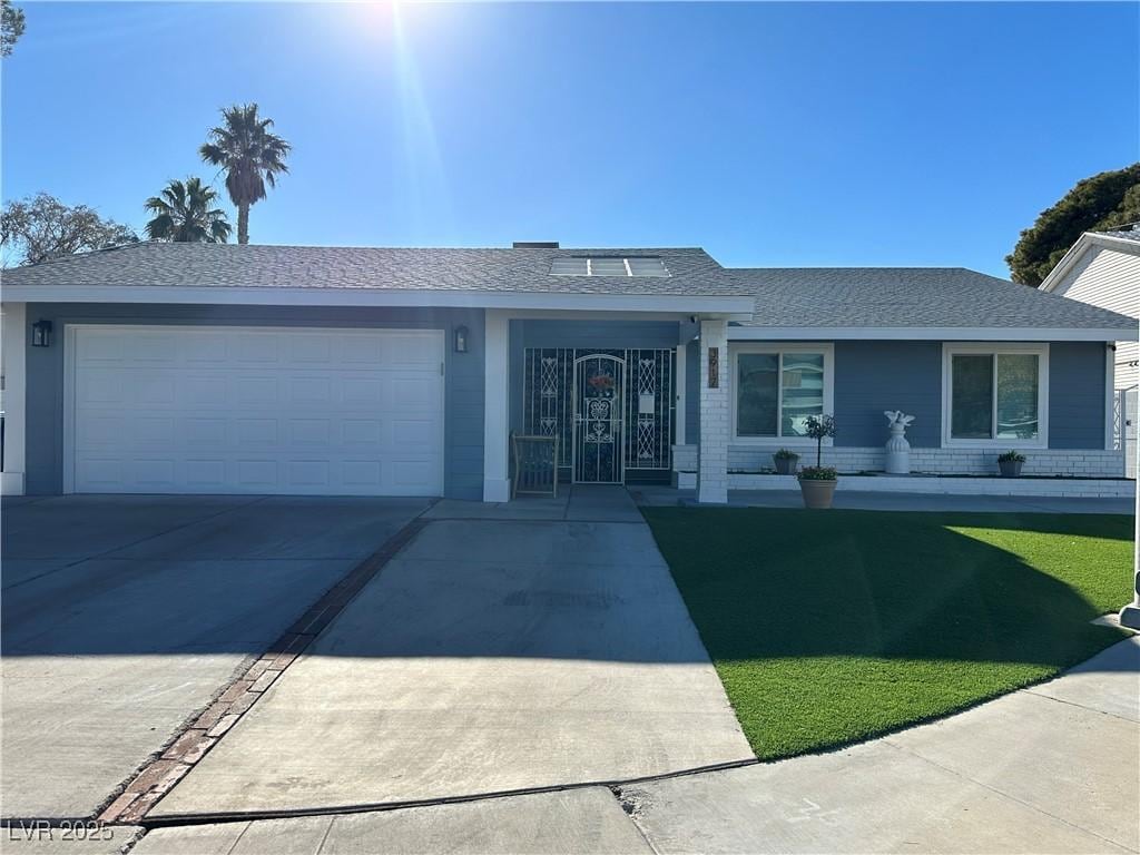 single story home featuring a front lawn and a garage