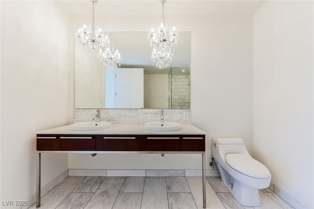 bathroom featuring vanity, toilet, and a chandelier