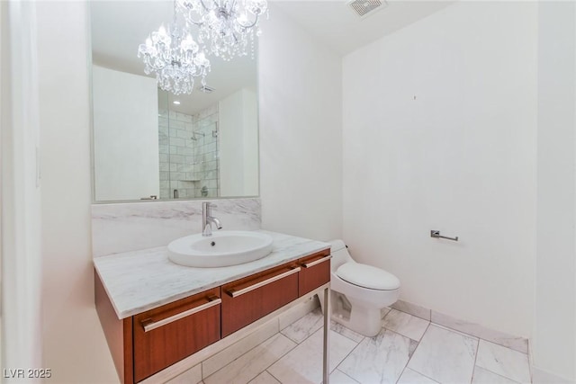 bathroom with vanity, toilet, a shower with door, and an inviting chandelier