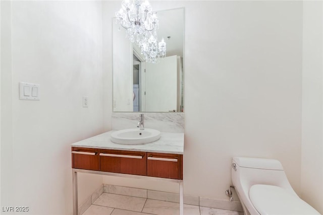 bathroom featuring tile patterned flooring, vanity, toilet, and a notable chandelier