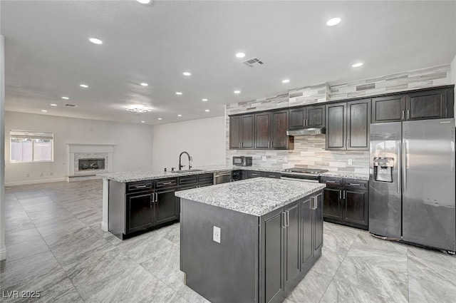 kitchen with kitchen peninsula, a center island, stainless steel appliances, and sink