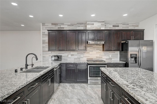 kitchen featuring dark brown cabinets, sink, light stone countertops, and stainless steel appliances