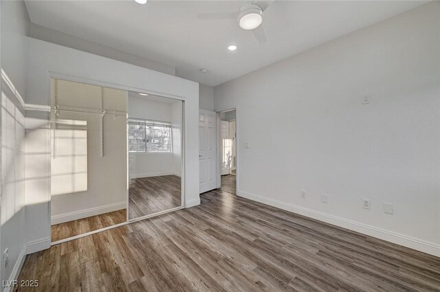 unfurnished bedroom featuring hardwood / wood-style floors, ceiling fan, and a closet