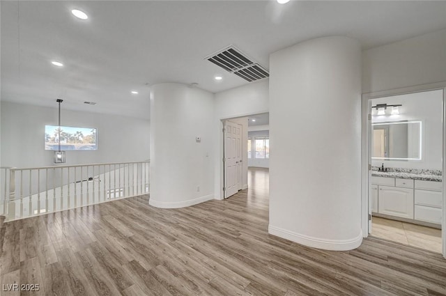 unfurnished room with sink and light hardwood / wood-style floors