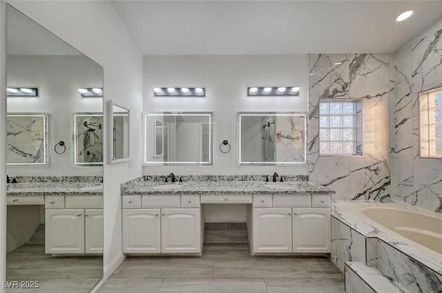 bathroom with vanity, tile walls, and a washtub