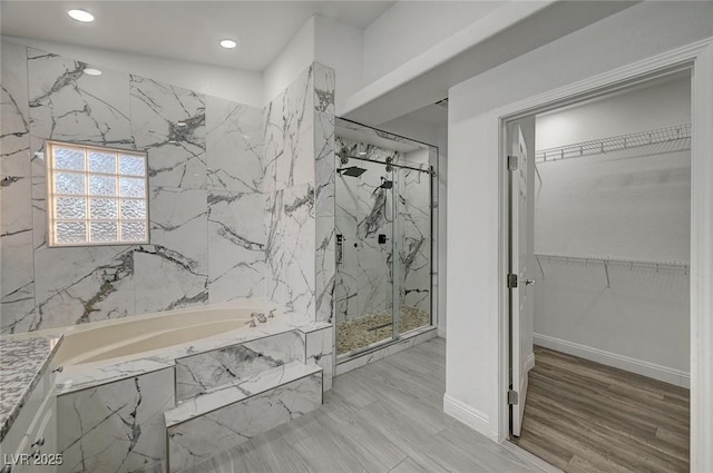 bathroom with hardwood / wood-style floors and shower with separate bathtub