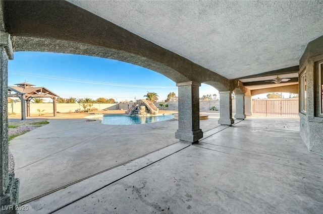 view of patio / terrace featuring a gazebo, ceiling fan, and a fenced in pool