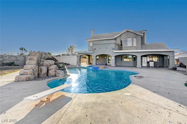 view of swimming pool featuring a diving board and a patio