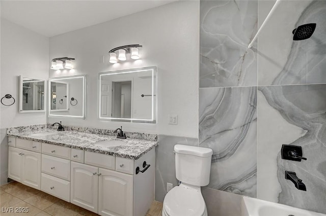 bathroom with tile patterned flooring, vanity, and toilet