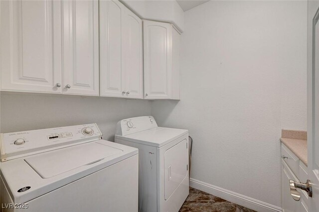 clothes washing area with washer and dryer and cabinets