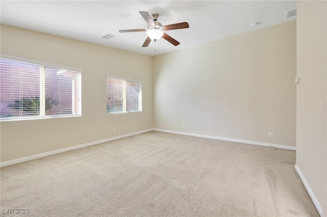 carpeted spare room featuring ceiling fan