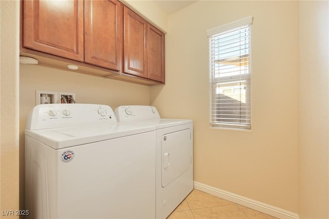 laundry room with washing machine and dryer, light tile patterned floors, and cabinets