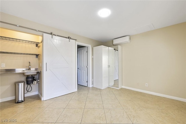 basement with a wall mounted air conditioner, a barn door, and light tile patterned floors