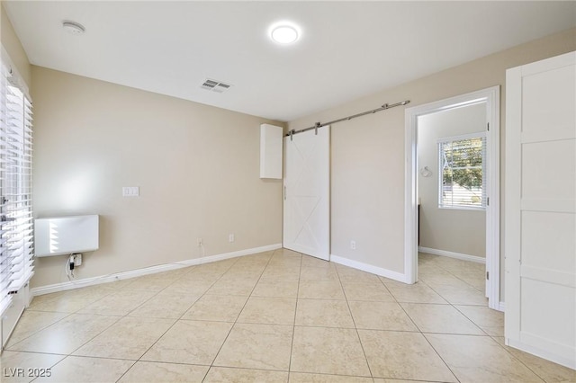 unfurnished bedroom with a spacious closet and light tile patterned flooring